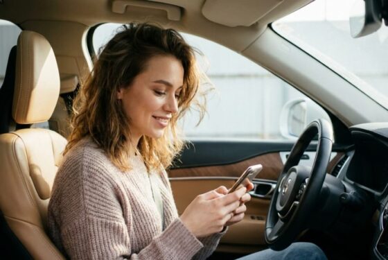 Kobieta pisząca flirtującą wiadomość na telefonie, uśmiech i emocje sugerujące rodzącą się miłość